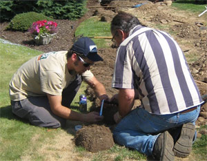 two of our The Woodlands sprinkler repair techs are fixing a broken system